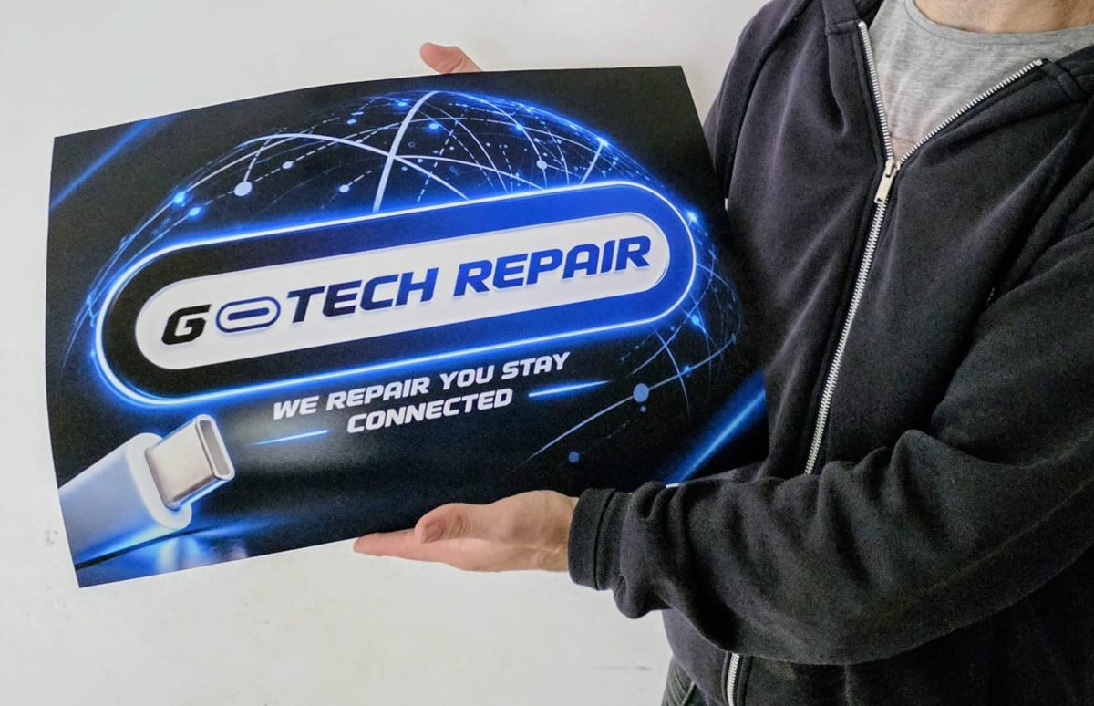 A printed G-Tech Repair poster, showing the logo with a USB-C connector built into the lettering
